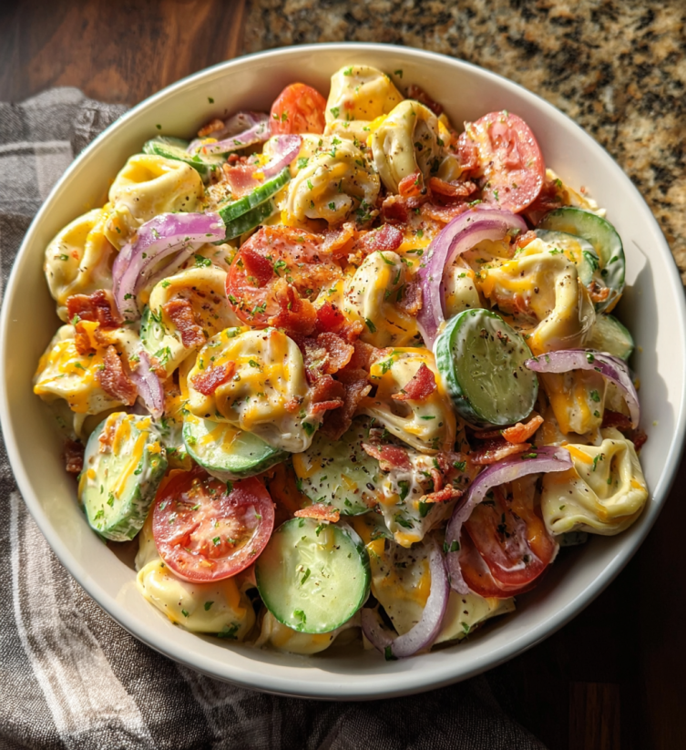 A bowl of food with tomatoes, cucumbers, onions, and bacon.