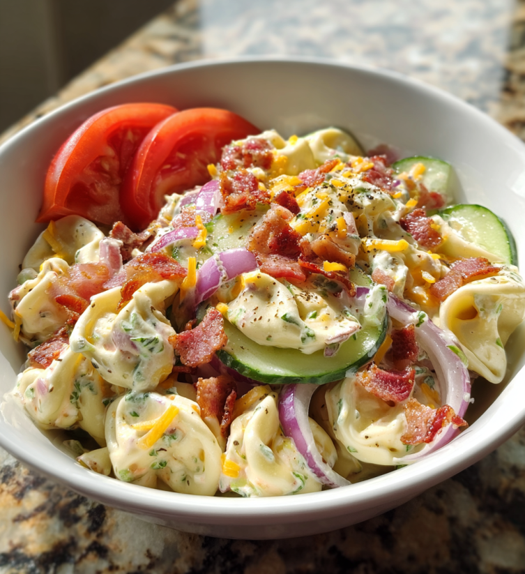 A bowl of food with tomatoes, cucumbers, and bacon.
