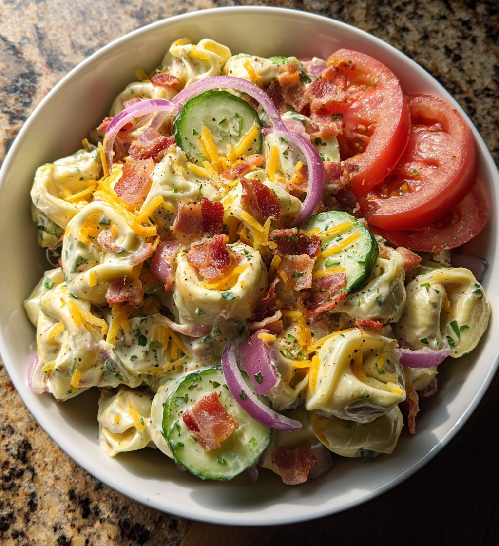 A bowl of food with tomatoes, onions, and bacon.