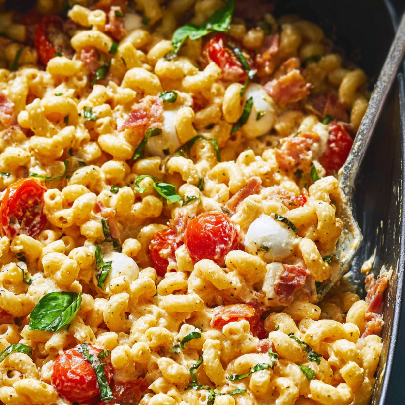 A dish of pasta with tomatoes and cheese.