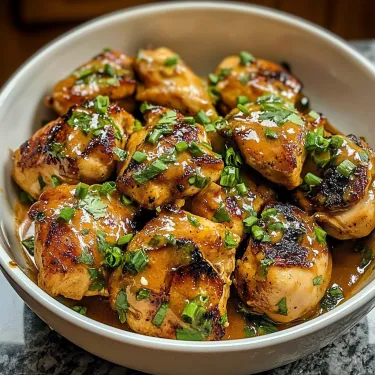 A bowl of chicken with sauce.