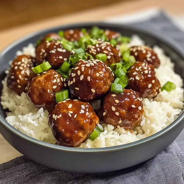 A bowl of meatballs with rice.