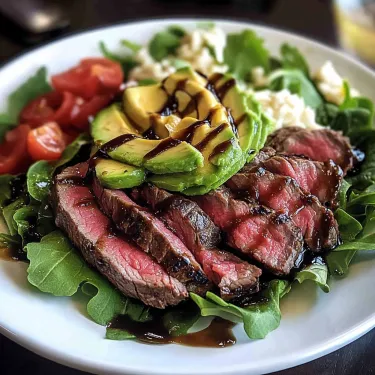 A plate of food with meat, avocado, and tomato.