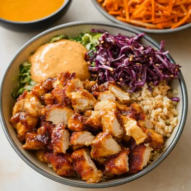 A bowl of food with rice, meat, and sauce.