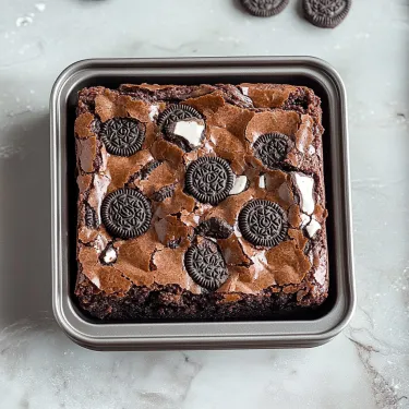 A square pan of chocolate brownie with Oreo cookies on top.
