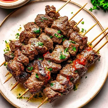 A plate of meat on a stick.