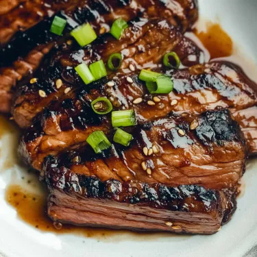 A plate of meat with green onions on top.