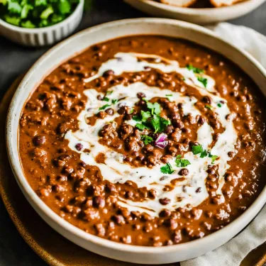 A bowl of soup with a spoon in it.