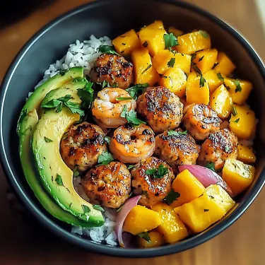A bowl of food with shrimp, avocado, and other vegetables.