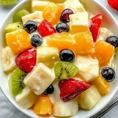 A bowl of fruit with strawberries, kiwi, and blueberries.
