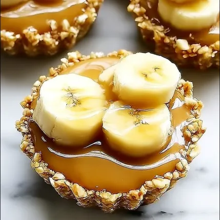 A bowl of banana slices with caramel sauce.