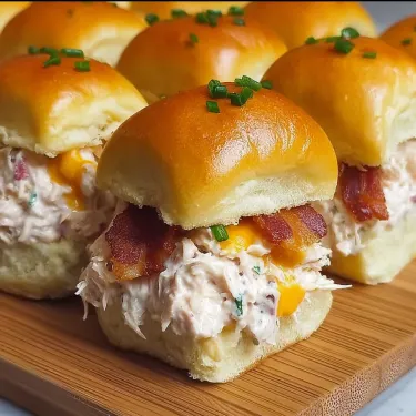 Bacon and chicken sandwiches on a wooden tray.