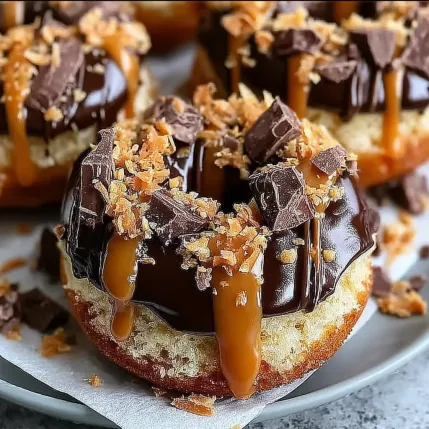 A chocolate covered donut with chocolate drizzle.