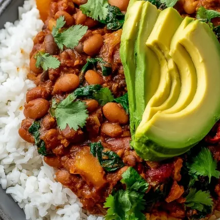 A bowl of food with rice, beans, and avocado.