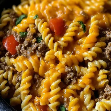 A bowl of pasta with meat and tomatoes.