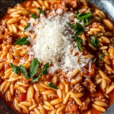 A bowl of pasta with cheese and meat.