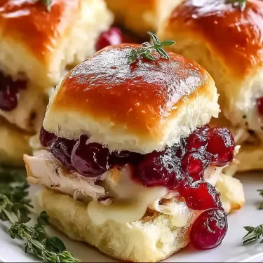 A plate of food with a sandwich and a cranberry.