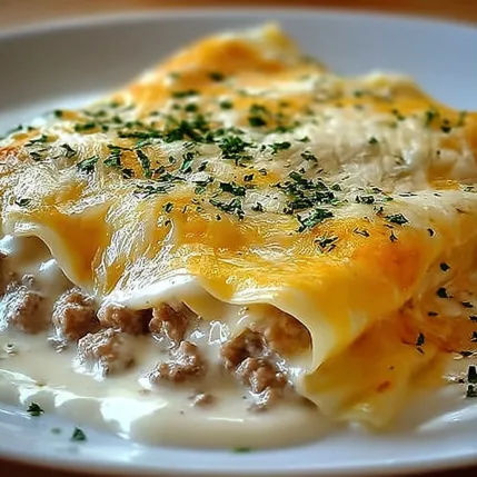 A white plate with a cheese and meat dish.