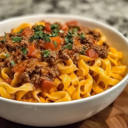 A bowl of pasta with meat sauce.