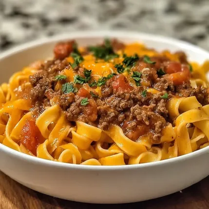 A bowl of pasta with meat sauce.