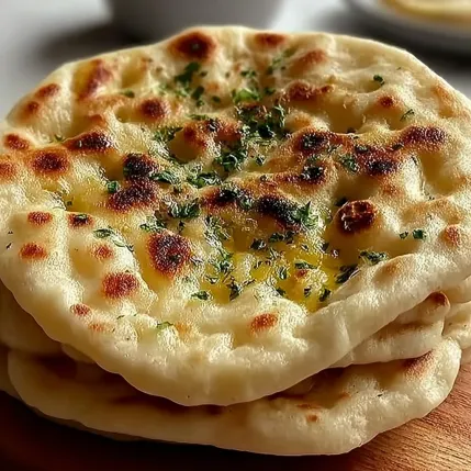 A stack of pita bread with cheese on top.