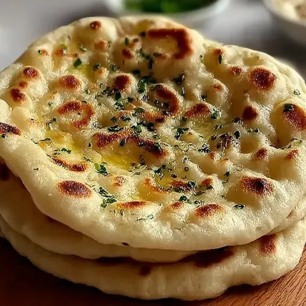 A stack of flatbreads with herbs on top.