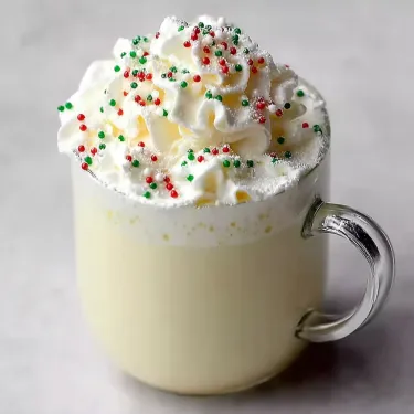 A cup of whipped cream with sprinkles.