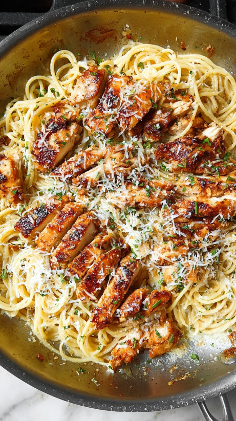 A dish of chicken and pasta with Parmesan cheese.
