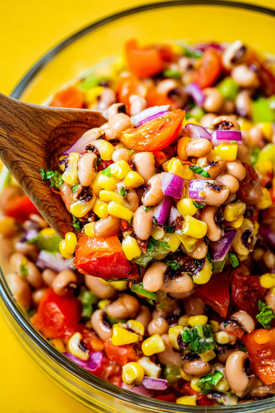 A wooden spoon is used to scoop up a dish of cowboy caviar.