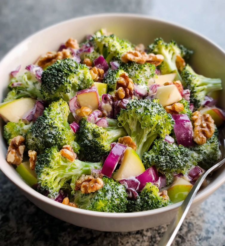 A bowl of broccoli salad with walnuts.