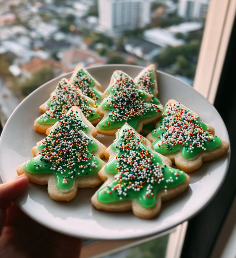 A plate of green and white cookies with sprinkles.