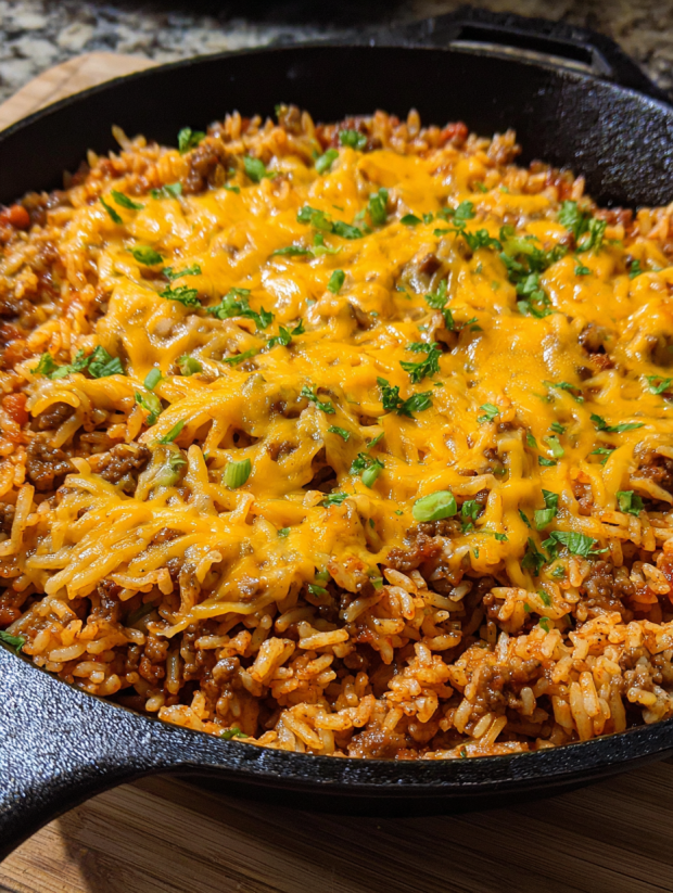A skillet full of cheesy sloppy joe rice.