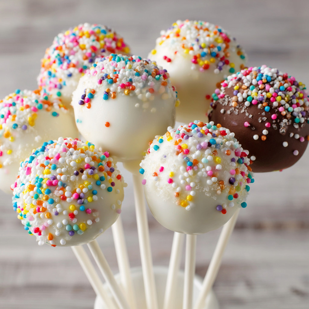 A bunch of cake pops on a stick.