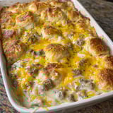 A white dish with biscuits and sausage gravy.