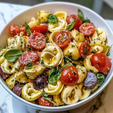 A bowl of pasta with tomatoes and basil.